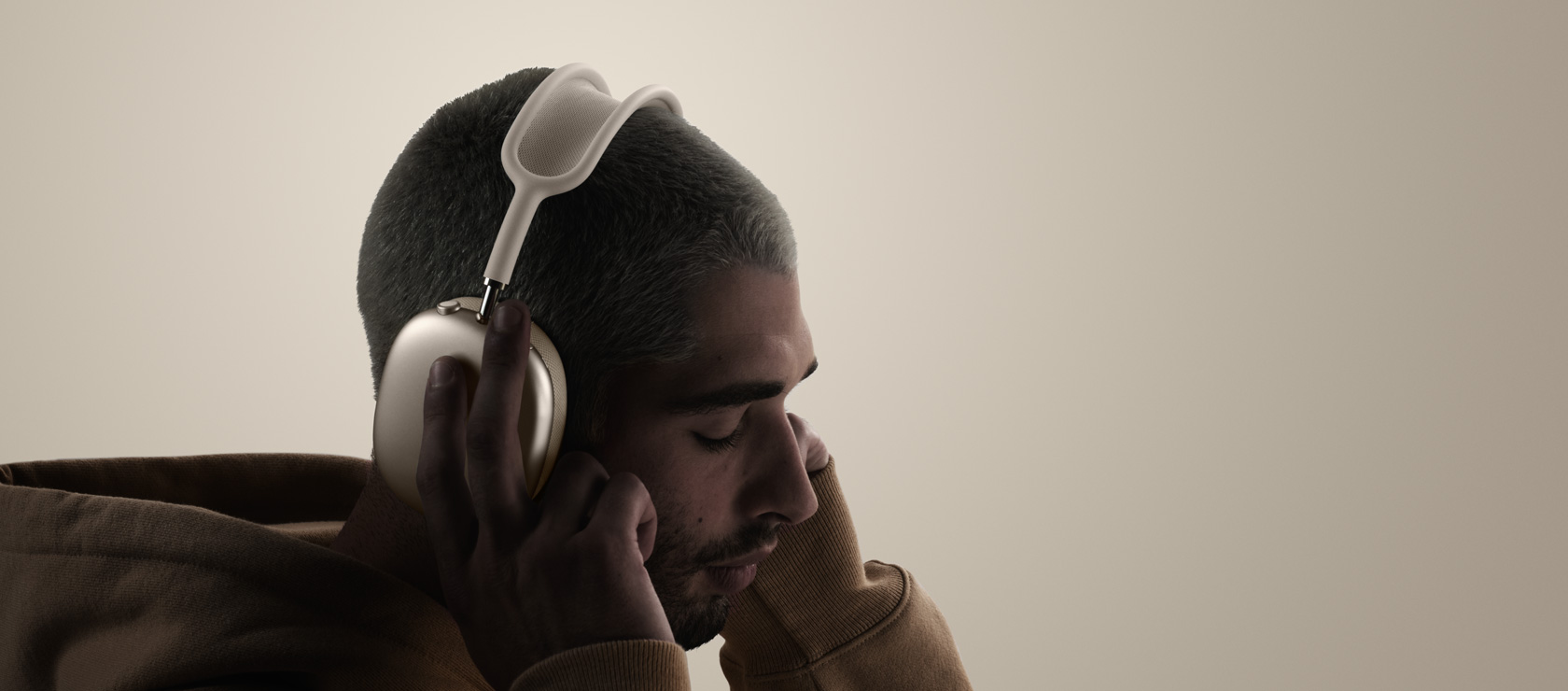 Žmogus su ausinėmis „AirPods Max 2“, šoninė išorinė pusė, liečiamos pagalvėlės