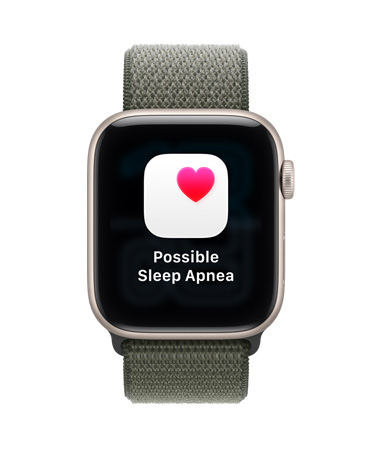 „Apple Watch SE 3“, aliuminio korpusas, žvaigždžių šviesos spalva, pranešimas apie galimą miego apnėją, rausva širdelė baltame kvadrate, dešinės pusės išorė, „Digital Crown“, sportinė apyrankė, miško spalva