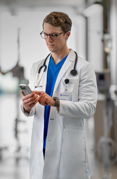 Un profesional sanitario utiliza un iPhone para consultar el progreso de una persona a su cargo en un hospital.