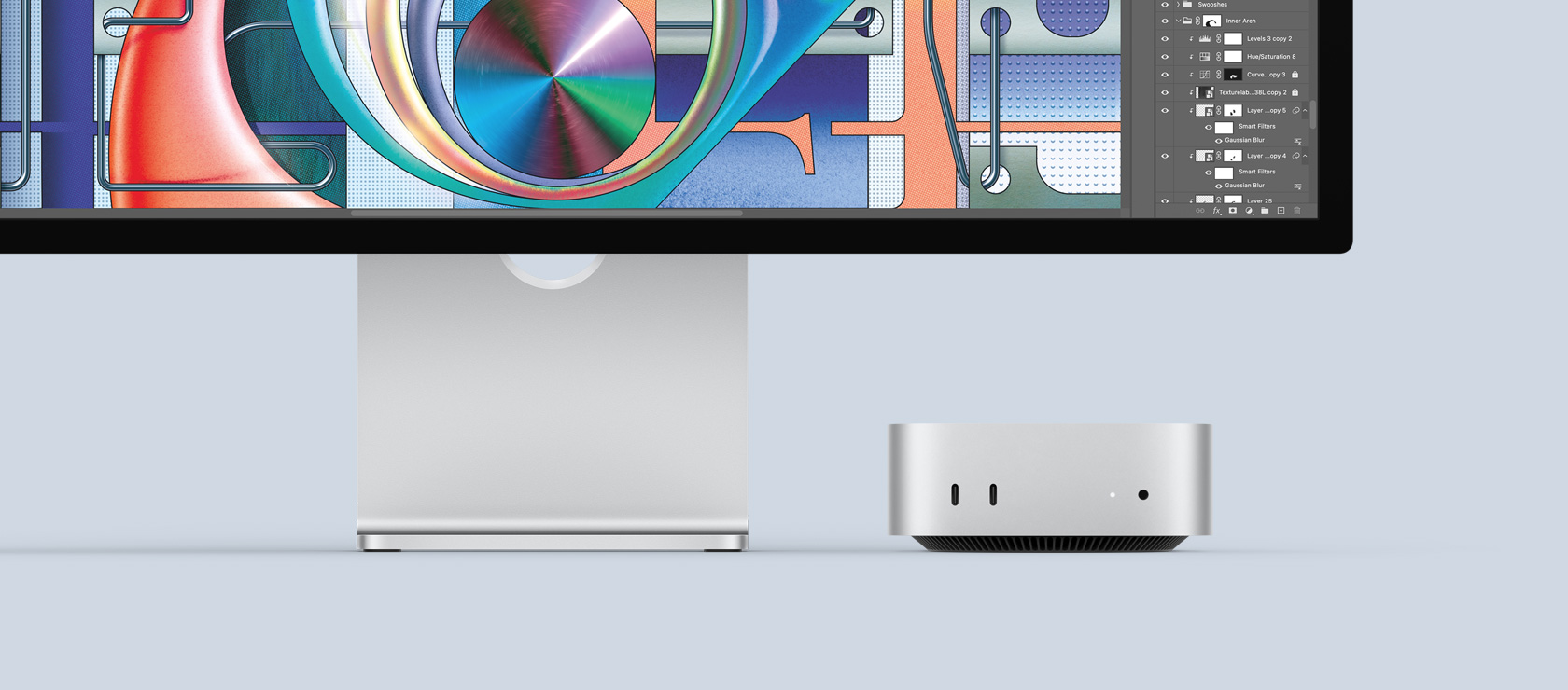 Hõbedase Mac mini eestvaade, nähtaval esipaneeli liidesed ja indikaatortuli, mahtudes kenasti Maci monitori alla, kuvatakse värvilist ekraani