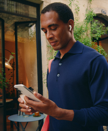 Une personne dans la rue regarde son iPhone et profite d’une connexion Wi‑Fi parfaitement stable malgré les transitions entre réseaux